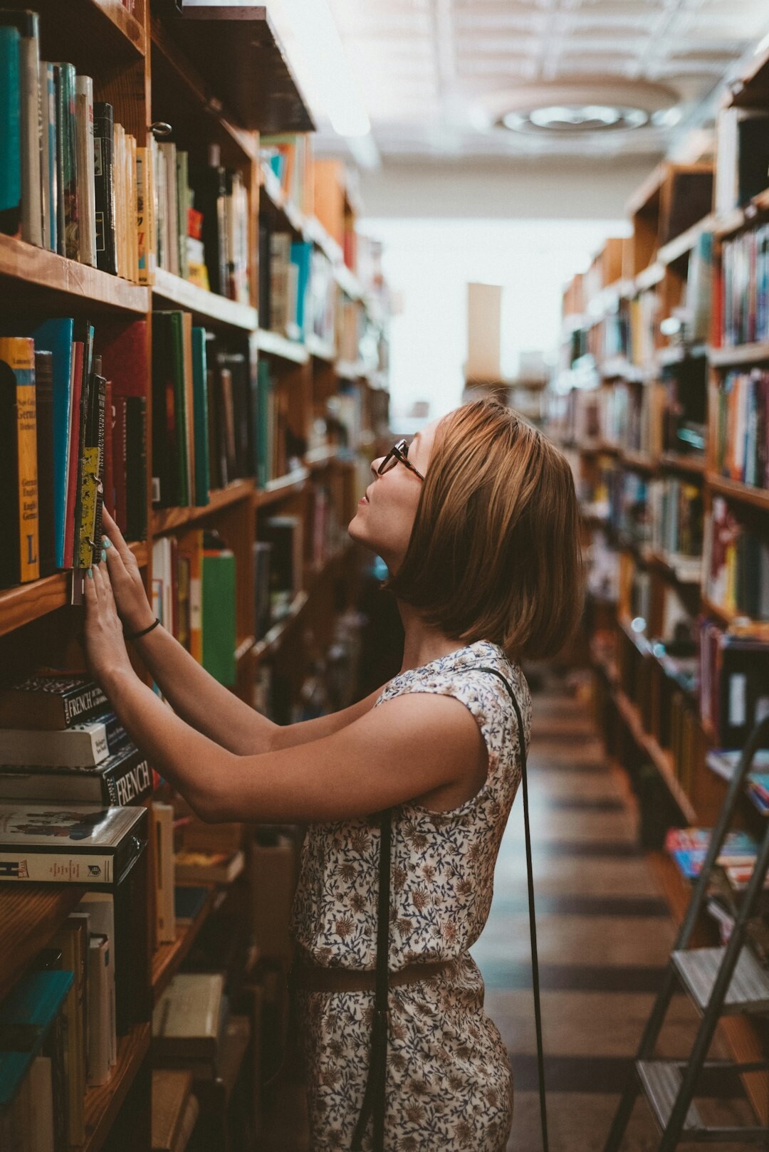 writer looking at old books in library