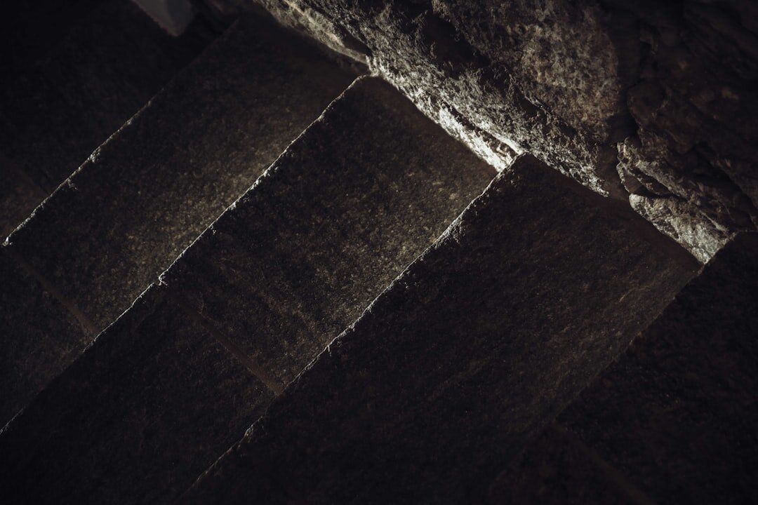 Dimly lit old stone staircase descending into shadow